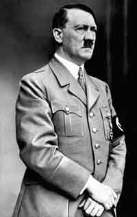 A stark photograph of Adolf Hitler. He is wearing a military coat, a Swastika on his arm. He looks sternly into the distance, looking serious, grim, and determined.