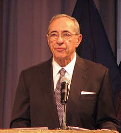 A photograph of New York Governor Mario Cuomo standing a t a podium and speaking into a microphone