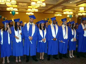 A photograph of students at a graduation. They are all wearing typical graduation apparel.
