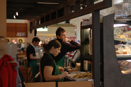 A photograph of young employees at a coffee shop in a mall.