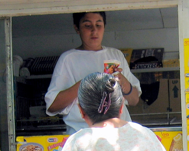 A photograph of a young man working in a mobile snack truck