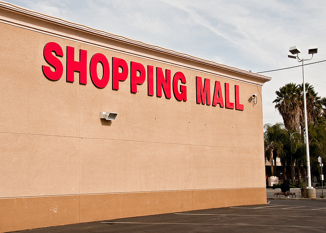 A photograph of the outside of a shopping mall from the parking lot.