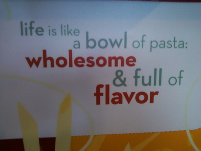 A sign that says “life is like a bowl of past: wholesome & full of flavor”