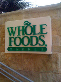 A photograph of a “Whole Foods Market” sign outside of the store in Austin, TX