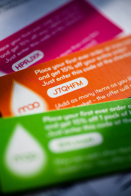 A photograph of three discount cards with online discount codes visible
