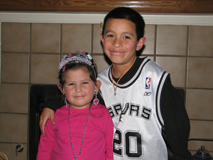 A photograph of a brother and sister. Both are under 10 years old. They are both smiling.