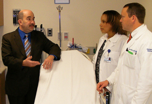 A photograph of three doctors consulting with each other in a an examination room