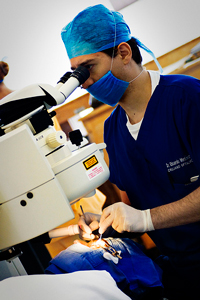 A photograph of a doctor looking into a scope during a procedure.