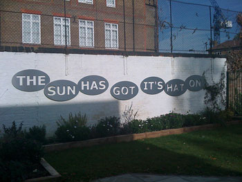 A photograph of a sentence painted on a wall. It reads, “The Sun has got it’s hat on.” should be “its” with no apostrophe