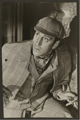 photo of an actor dressed as Sherlock Holmes in checkered cap and plaid coat with ascot.