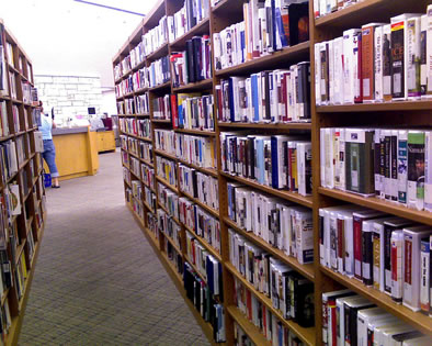 A row between two tall shelves of library media