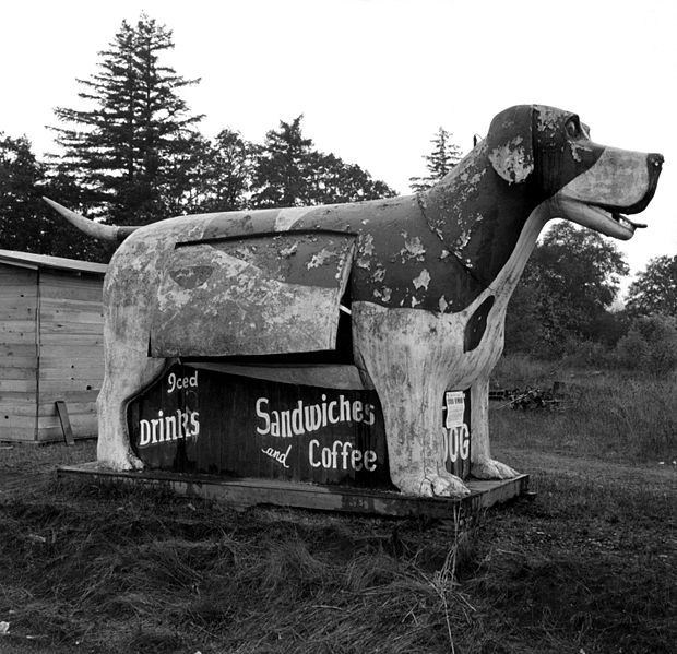 A giant wooden floppy eared dog with its tongue hanging out is advertisement for a refreshment stand in Oregon