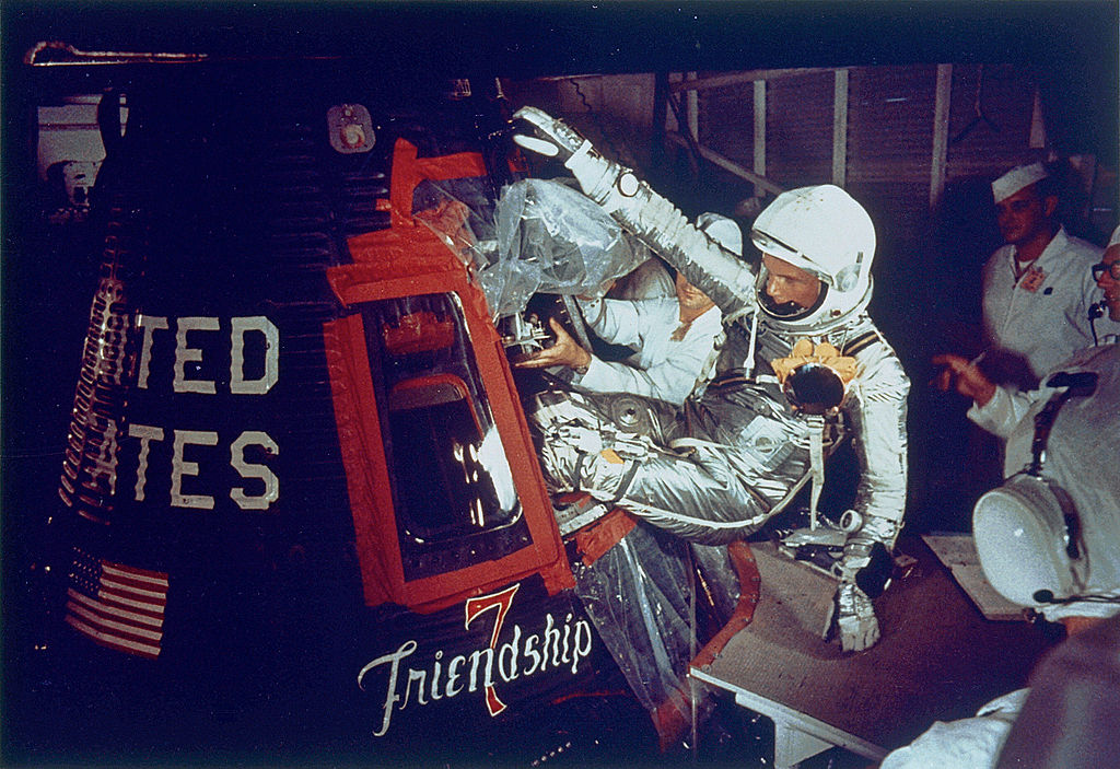 A colored photograph of astronaut John Glenn entering the space capsule, Friendship 7.