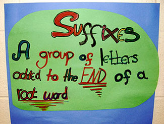A handmade sign that reads “Suffixes: A group of letters added to the end of a root word.