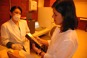 A photograph of two female scientists in a lab. They appear to be discussing something.