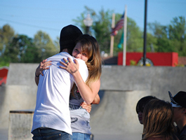 A photograph of a boy and a girl hugging each other.