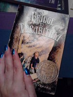 A photograph of a woman’s hand touching a copy of “The Bridge of Terabithia.”