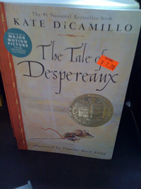 A photograph of the cover of the book “The Tale of Despereaux.” It shows an illustration of a little mouse running across the bottom