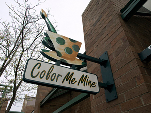 A photograph of a sign that reads “Color Me Mine.”