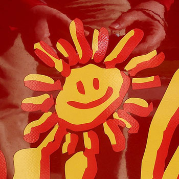 An image of a happy, smiling representation of the Sun in bright yellow and red.