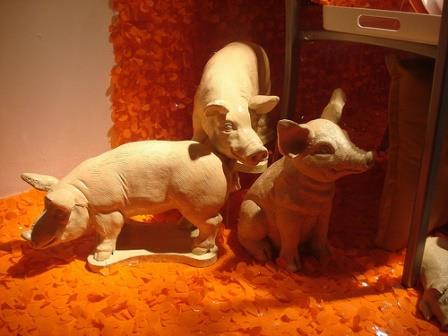 A photograph of three pigs carved from wood