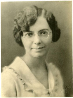 A photograph of a woman in her 20s wearing glasses. The photo was taken in the 1930s.