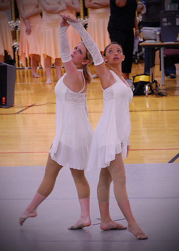 two young women dancing in a competition. They look graceful and flowing.