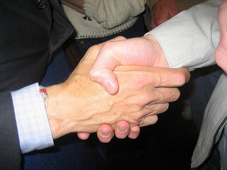 A photograph of two hands grasped in a handshake