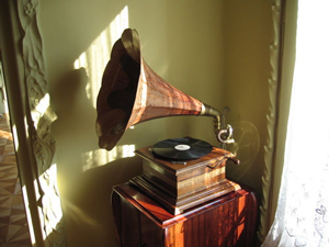 A photograph of an antique phonograph. It is a device that plays musical recordings like a record player, but it uses a bell shaped horn to project the sound.