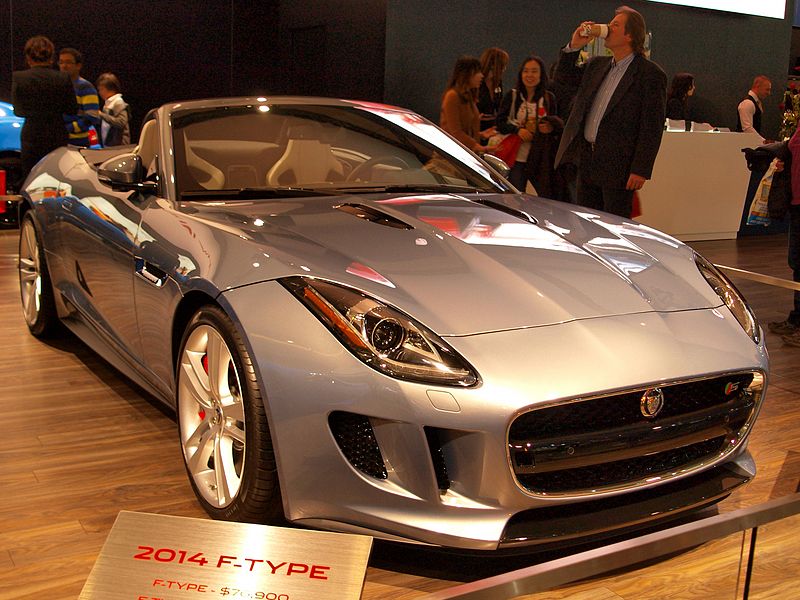 A photograph of a 2014 Jaguar F-Type convertible on the showroom floor.