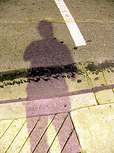 A photograph of a person�s shadow on a sidewalk.