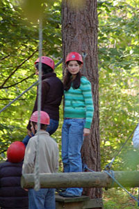 A photograph of several students wearing climbers helmets waiting to participate in something