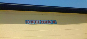 A photograph of a sign outside of a coffee shop that reads “Cofee Shop”