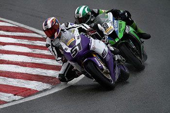 A photograph of two racing motorcycles going into a turn.