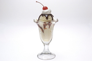 A photograph of an ice cream sundae with a cherry on top