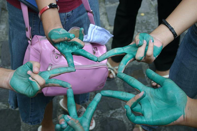 A photograph of five people holding their fingers out in a ‘v’ sign that makes a star