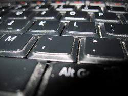 A photograph of the comma and period keys on a computer keyboard