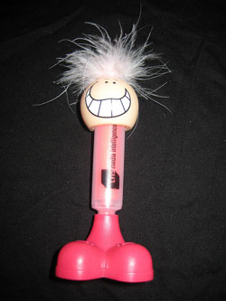 Photo of a pink highlighter; its cap is two pink feet and the other end is topped by a silly face and a head of crazy hair that sticks out