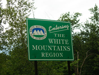 A photograph of a sign that reads “Entering the White Mountains Region.”