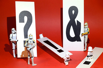 A photograph of various Star Wars action figures working with cards that have various punctuation marks on them.