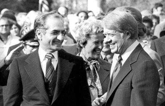 Image of the Shah and Carter standing side by side laughing